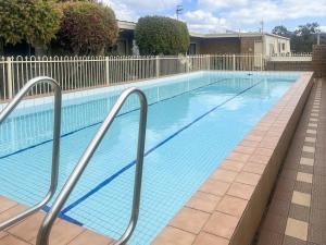 マラクータにあるUnit 11, 6-8 Buckland Drive, Mallacootaの白いフェンス付きの青い大型スイミングプール