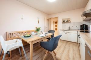 a kitchen and dining room with a wooden table and chairs at Ferienhaus zur Weinlaube in Thurmansbang +14 photos