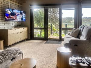 マラクータにあるUnit 11, 6-8 Buckland Drive, Mallacootaのソファと薄型テレビのあるリビングルーム