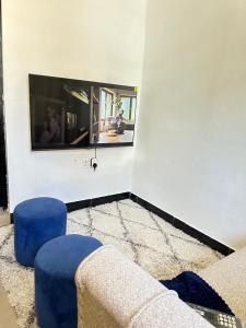 a living room with a couch and two blue stools at Stay with Recxy 1 in Dar es Salaam