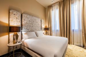 a bedroom with a white bed and a large window at Palazzo Rota Luxury Apartments in Venice
