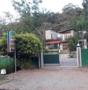 a building with a green fence and a gate at Elephant View Hotel in Damana