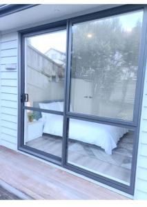 a window with a view of a patio at Long Bay Breeze Ensuite in Auckland