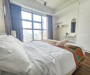 a large white bed in a room with a large window at Holiday Paradise in Kuala Lumpur