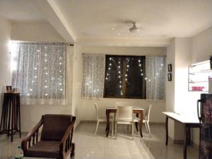 a dining room with a table and chairs and a window at Cinnamon House in Pune