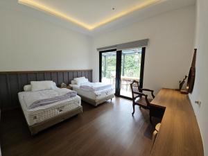 une chambre avec deux lits et un bureau et une fenêtre dans l'établissement Villa Pine Hill Coolibah, à Gegarbensang