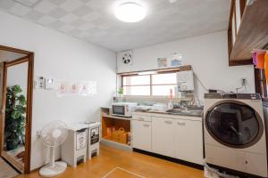 a kitchen with a washing machine and a sink at Jikka Japan in Izumi-Sano