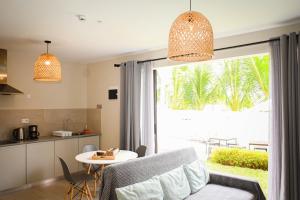 a kitchen and a living room with a table and a window at Bois Mapou Self Catering Apartments Unit 103 in Rivière Noire