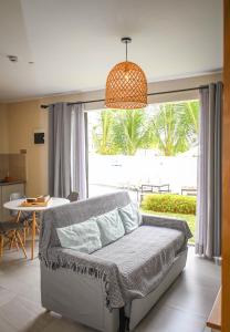 a bedroom with a bed and a table and a window at Bois Mapou Self Catering Apartments Unit 103 in Rivière Noire