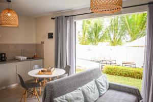 a kitchen and a living room with a table and a window at Bois Mapou Self Catering Apartments Unit 103 in Rivière Noire
