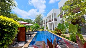 Una piscina con sillas y sombrillas al lado de un edificio. en Ananthara Resort, en Anuradhapura