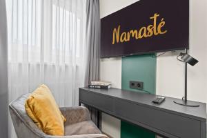 a room with a desk and a chair and a sign at NAMASTÉ Homes - Ferienwohnung mit Balkon - Garage in Bamberg