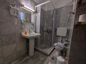 a bathroom with a shower and a sink and a toilet at Grivas Apartments in Sivota +57 photos