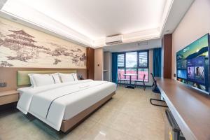 a hotel room with a large bed and a flat screen tv at Haier International Hotel Vientiane Wattay Airport Branch offers free airport pick-up and drop-off upon prior reservation. in Vientiane