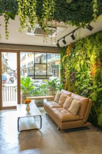 een bank in een woonkamer met een groene muur bij Wat We See Hostel in Khlong San