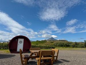 a picnic table and two chairs next to a tent at Framtid Camping Lodging Barrels in Djúpivogur