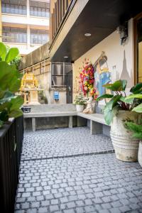een bank in een gebouw met bloemen en planten bij Wat We See Hostel in Khlong San