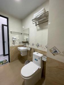 a bathroom with a white toilet and a sink at Khách sạn Đức Phúc in Dồng Văn