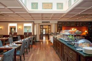 a restaurant with tables and chairs and a buffet at Eurostars Montgomery in Brussels