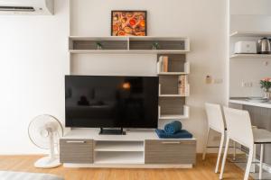a living room with a large entertainment center with a flat screen tv at 1 BR Suite 8-198 at Ozone Condo near Kata beach and surf in Kata Beach