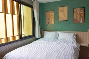 een slaapkamer met een wit bed met een raam bij Wat We See Hostel in Khlong San +17 foto's