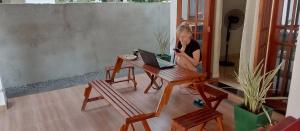 a woman sitting at a table with a laptop computer at Serene Villa in Beruwala