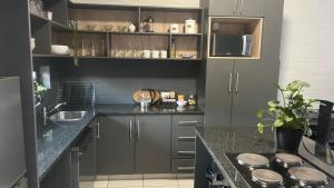 a kitchen with gray cabinets and a counter top at MiCasa 62 in Potchefstroom +22 photos