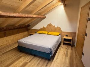 a bedroom with a bed in a room with wooden ceilings at Caluma El Paradis in Comune Rivamonte Agordino