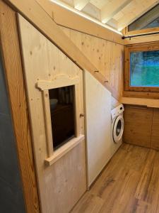 a tiny house with a window and a washing machine at Caluma El Paradis in Comune Rivamonte Agordino +16 photos