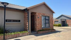 a brick house with a window and a street light at MiCasa 62 in Potchefstroom