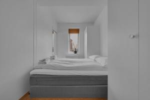 a bed in a room with a white wall at Centrally located apartment in Tromsø in Tromsø