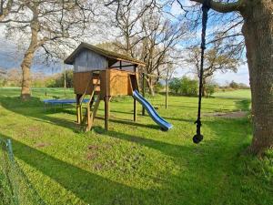 a playground with a slide and a swing at Ferienhof Schlottmann in Achtrup