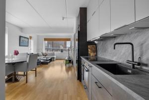 a kitchen with a sink and a living room at Centrally located apartment in Tromsø in Tromsø