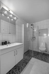 a white bathroom with a sink and a toilet at Centrally located apartment in Tromsø in Tromsø +13 photos