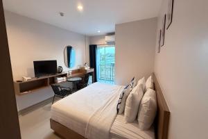 a bedroom with a bed and a desk with a computer at SKM Paradise Mae Sai in Mae Sai