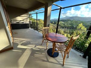 a table and two chairs on a balcony with a view at Chamarel - Enba Lakaz in Chamarel +11 photos