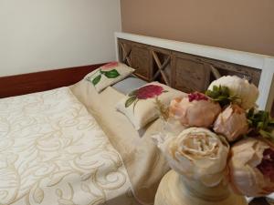Una cama con dos flores encima. en Penzion Villa Marion, en Mariánské Lázně