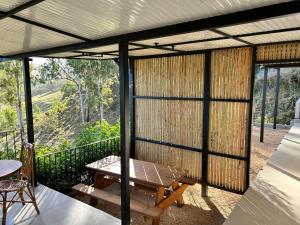 a screened in porch with a bench and a table at Chamarel - Enba Lakaz in Chamarel