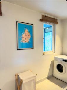 a laundry room with a washing machine and a window at Chamarel - Enba Lakaz in Chamarel