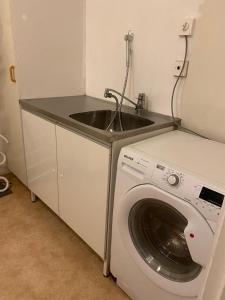 a kitchen with a sink and a washing machine at Entire 4 rooms Cozy apartment in central Älmhult in Älmhult