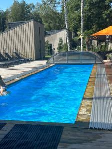 a large blue swimming pool with a clear roof at Luxury Villa with Pine Forest View, Palanga in Palanga