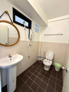 a bathroom with a sink and a toilet and a mirror at Mr. Black Resort in Haad Rin