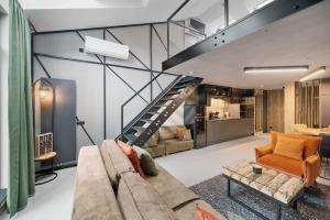 a living room with a couch and a staircase at Calm Sauna & Jacuzzi by OneApartments in Sopot