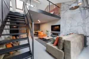 a living room with a staircase and a couch at Calm Sauna & Jacuzzi by OneApartments in Sopot