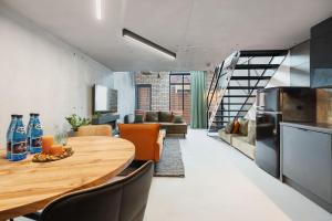 a kitchen and dining room with a wooden table and chairs at Calm Sauna & Jacuzzi by OneApartments in Sopot +15 photos