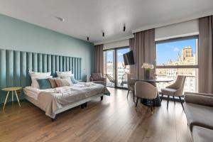 a bedroom with a bed and a table and chairs at DEO PLAZA Apartments & Riverside by Downtown Apartments in Gdańsk
