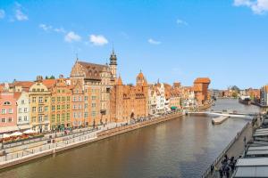 a view of a river in a city with buildings at DEO PLAZA Apartments & Riverside by Downtown Apartments in Gdańsk