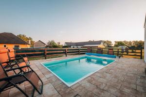 a swimming pool on a patio with a fence at Čertova chalupa 