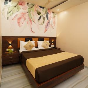 a bedroom with a bed with a painting on the wall at Hotel Royce Executive Near US Consulate, Bandra Kurla Complex in Mumbai