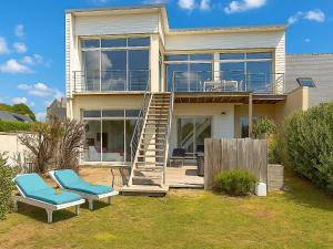 a house with two chairs and a staircase in front of it at Villa Santec in Santec